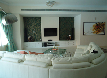 Family room with curved white sectional sofa and built-in media wall