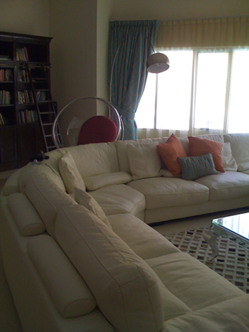 Cozy lounge with large white sectional, reading area, and library shelving