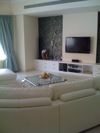 TV lounge with white seating and clean media wall in Dubai villa interior